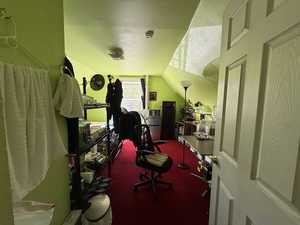 Bedroom with a textured ceiling, carpet flooring, and lofted ceiling