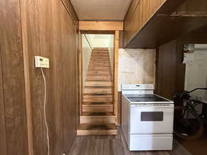Stairs featuring wood finished floors and wooden walls