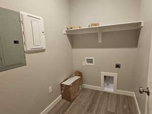 Washroom with wood finished floors, hookup for a washing machine, hookup for an electric dryer, baseboards, and electric panel