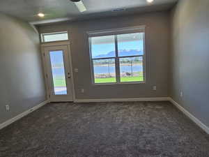 Unfurnished room with dark colored carpet, baseboards, and a textured ceiling