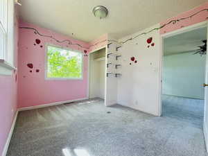 Unfurnished bedroom with a textured ceiling, carpet flooring, baseboards, and a closet