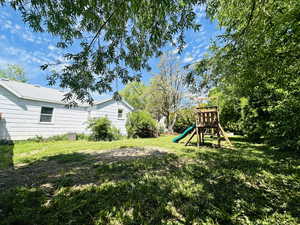 View of grassy yard featuring a playground