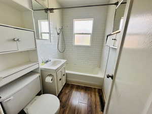 Full bathroom featuring wood finished floors, toilet, vanity, and shower / tub combination