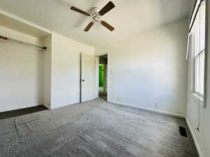 Unfurnished bedroom with carpet, baseboards, a ceiling fan, and a closet