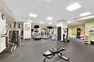 Gym with a drop ceiling and baseboards