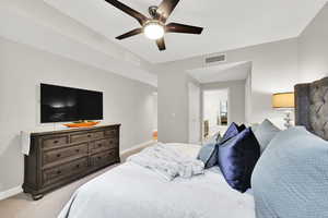Bedroom with baseboards, light colored carpet, and a ceiling fan