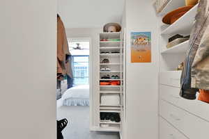 Walk in closet with carpet and a ceiling fan