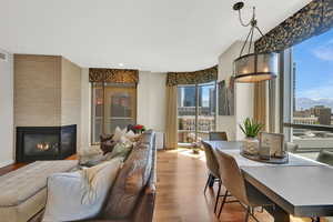 Dining room featuring wood finished floors, healthy amount of natural light, a fireplace, and recessed lighting