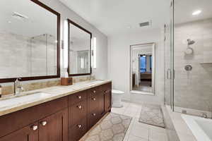 Full bath featuring double vanity, a shower stall, tile patterned flooring, toilet, and tiled tub