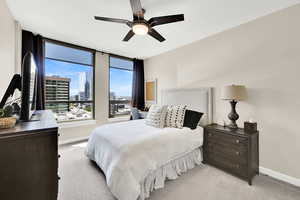 Bedroom with baseboards, light carpet, and ceiling fan