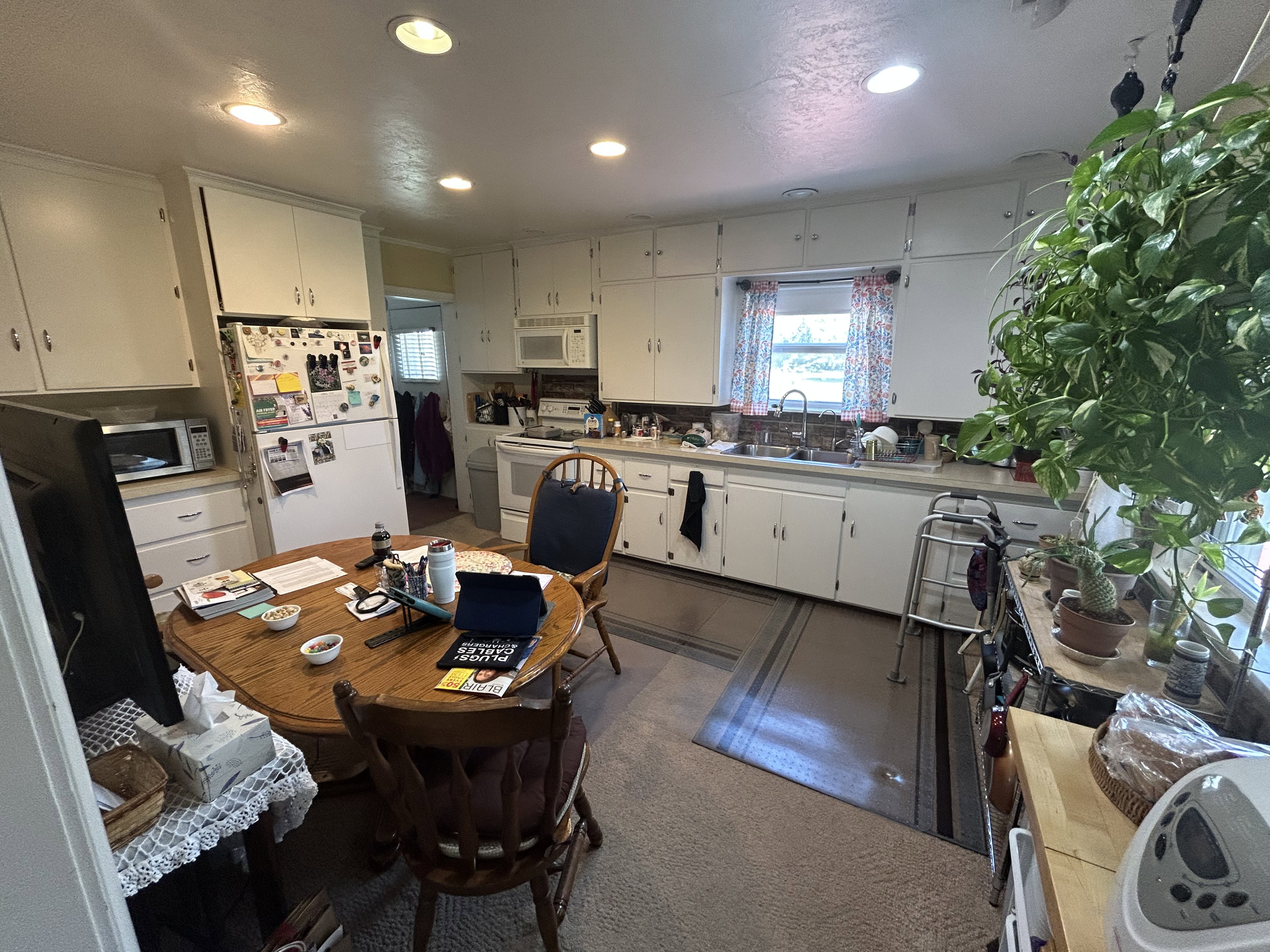 Kitchen featuring white appliances, recessed lighting, white cabinets, a sink, and light countertops