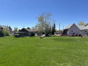 View of grassy yard with a deck