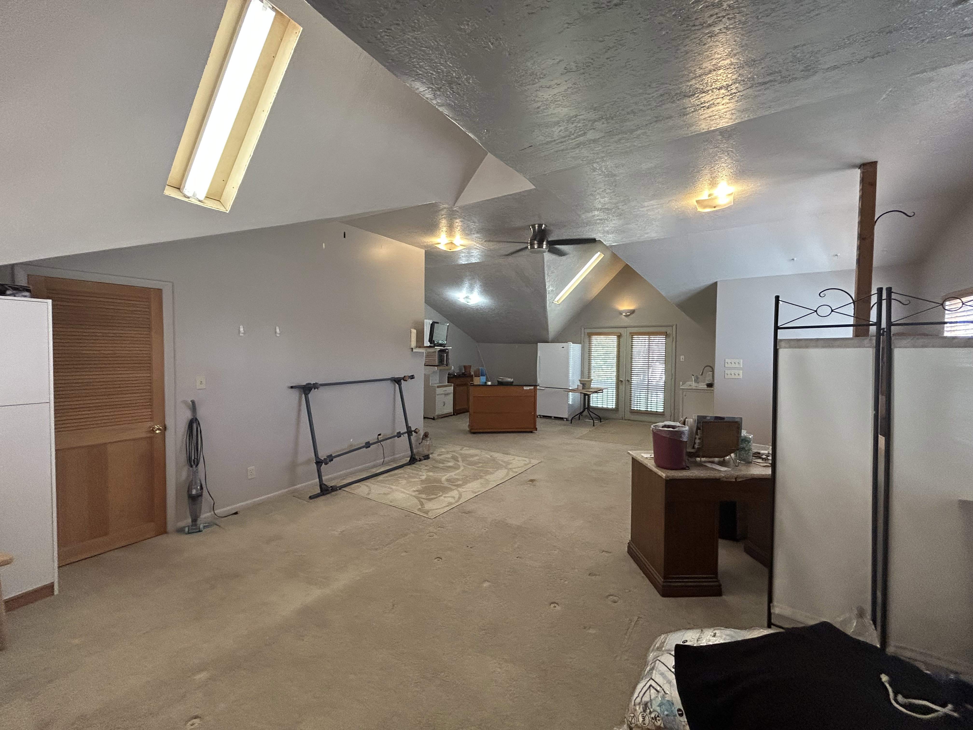 Additional living space with lofted ceiling, light colored carpet, ceiling fan, and baseboards