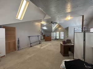 Additional living space with lofted ceiling, light colored carpet, ceiling fan, and baseboards