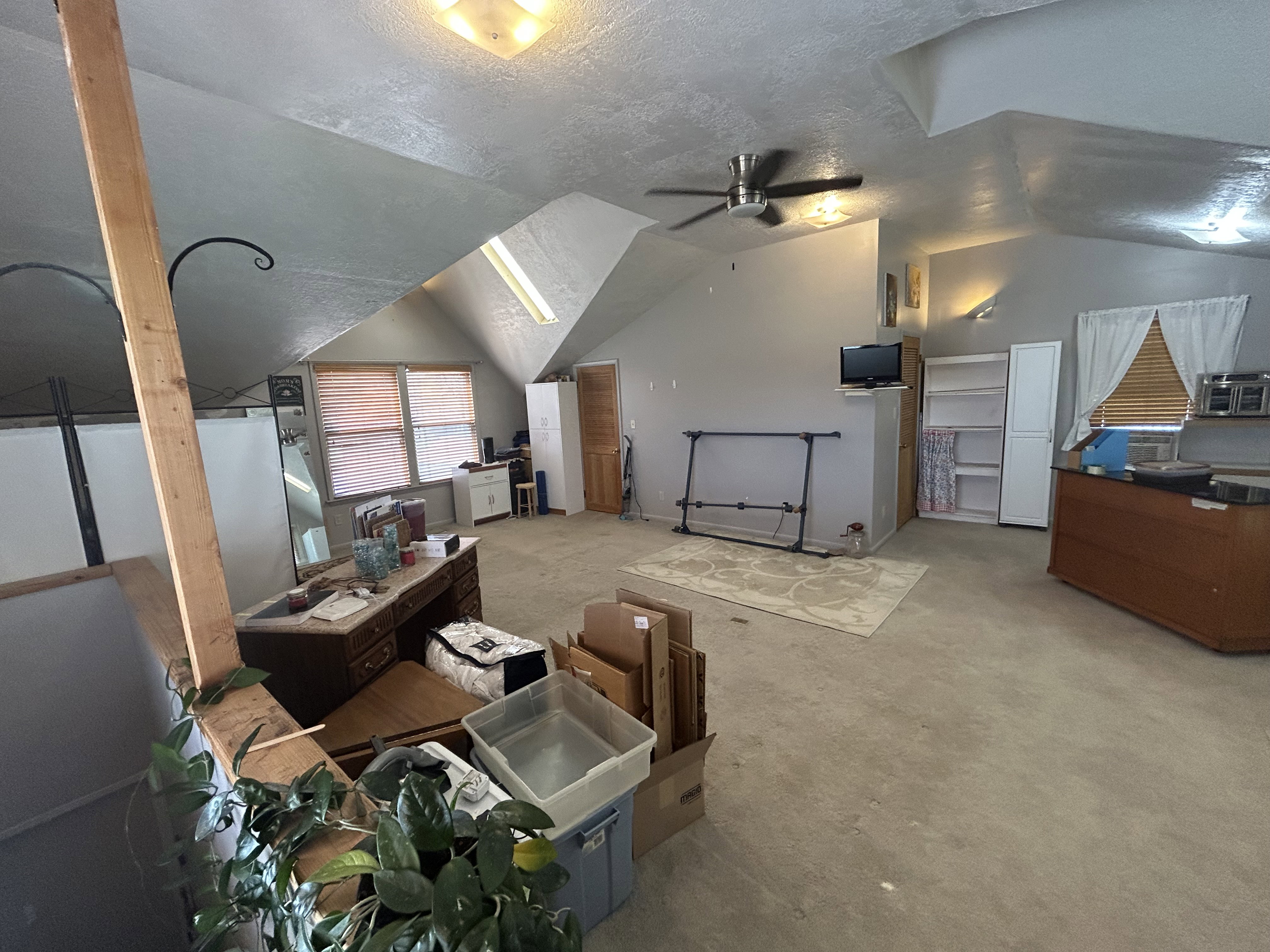 Additional living space with lofted ceiling, ceiling fan, a textured ceiling, and light carpet