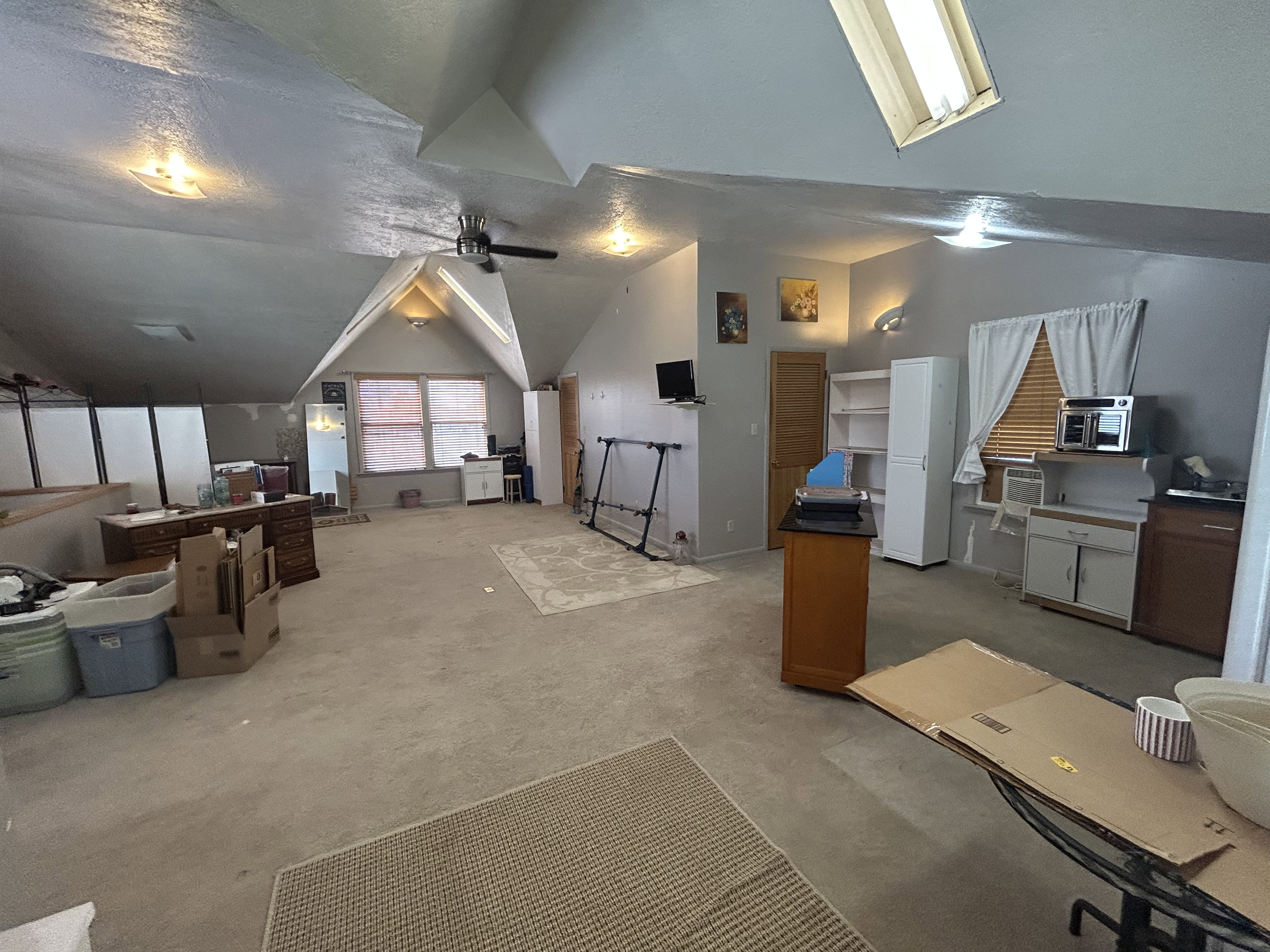 Bonus room featuring lofted ceiling, light carpet, and a ceiling fan