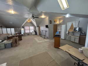 Bonus room featuring lofted ceiling, light carpet, and a ceiling fan