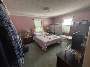 Bedroom with carpet flooring, a textured ceiling, and ornamental molding
