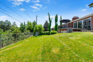 View of yard featuring stairs, central AC, and a deck