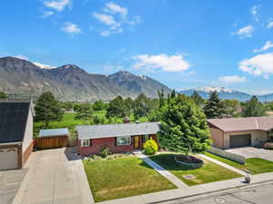 View of front of home featuring a chimney, driveway, and a mountain view