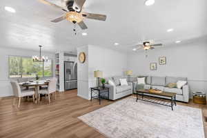 Living area with ceiling fan, crown molding, a chandelier, recessed lighting, and light wood-type flooring