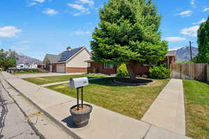 Obstructed view of property with a mountain view, an attached garage, driveway, and brick siding