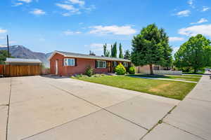 Ranch-style home with brick siding, a mountain view, and concrete driveway