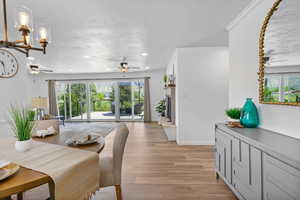 Dining space featuring a ceiling fan, healthy amount of natural light, light wood-type flooring, recessed lighting, and a textured ceiling