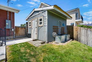 View of outdoor structure featuring a gate and an outbuilding
