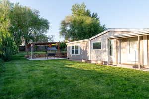 View of the home and beautiful yard featuring a patio with a pergola