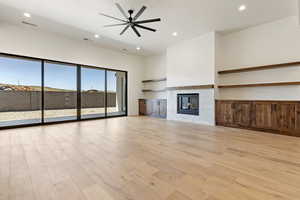 Unfurnished living room with recessed lighting, light wood-type flooring, a fireplace, and ceiling fan