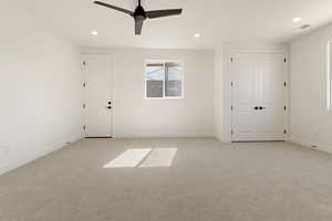 Empty room featuring light carpet, recessed lighting, baseboards, and a ceiling fan