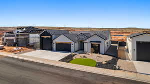 Modern farmhouse style home featuring an attached garage, concrete driveway, and stucco siding