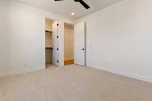 Unfurnished bedroom featuring light colored carpet, a spacious closet, baseboards, recessed lighting, and a closet