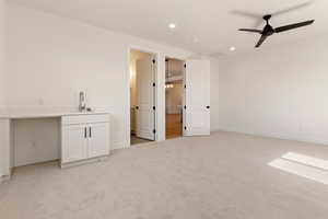 Bar featuring a sink, ceiling fan, recessed lighting, light colored carpet, and baseboards