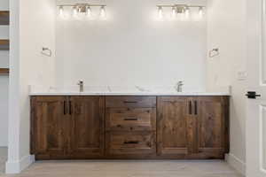 Bathroom featuring baseboards and double vanity