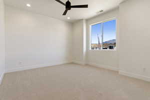 Carpeted spare room featuring baseboards, a ceiling fan, and recessed lighting