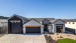 Modern inspired farmhouse featuring a garage, driveway, stucco siding, board and batten siding, and a tiled roof