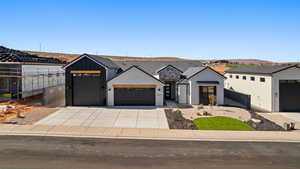 View of front of house featuring an attached garage, driveway, stucco siding, a tiled roof, and fence