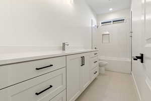 Bathroom with toilet, vanity, shower / tub combination, and tile patterned flooring