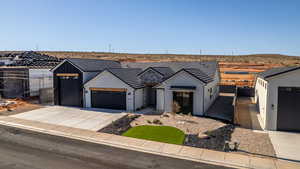 Modern inspired farmhouse with an attached garage, concrete driveway, stucco siding, and fence
