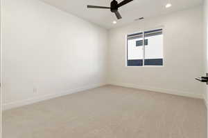 Carpeted spare room featuring ceiling fan, recessed lighting, and baseboards