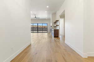 Hall with baseboards, light wood-type flooring, and recessed lighting