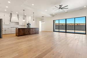 Kitchen featuring custom exhaust hood, open floor plan, recessed lighting, stainless steel appliances, and backsplash