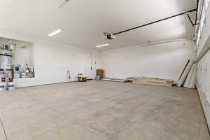 Garage featuring secured water heater and a garage door opener