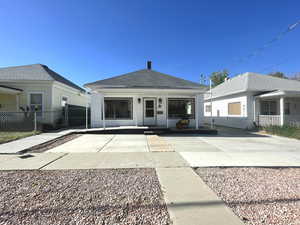 Back of house featuring fence, a porch, and roof with shingles