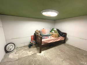 Bedroom with unfinished concrete floors