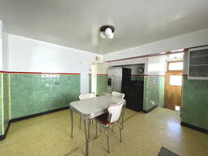 Dining area with wainscoting and tile walls