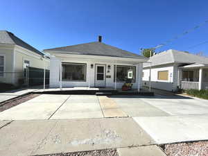 View of front of home with a porch, fence, and roof with shingles