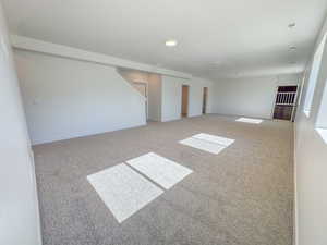 Carpeted spare room featuring baseboards